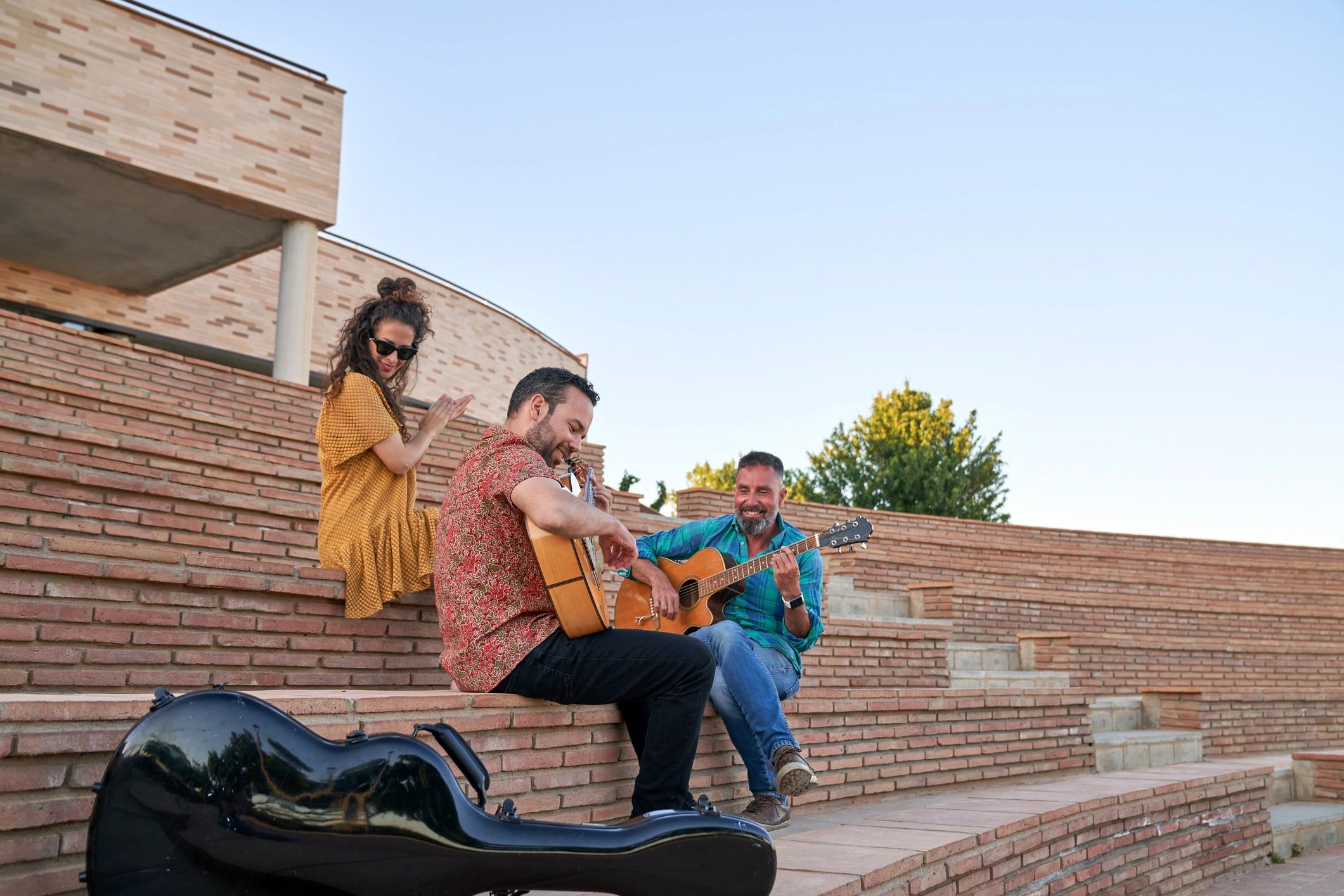 Musicians playing acoustic guitars outdoors